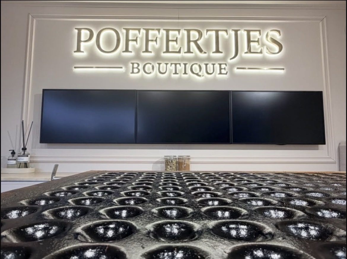 Interieur van de mobiele poffertjeskraam met verlicht logo
