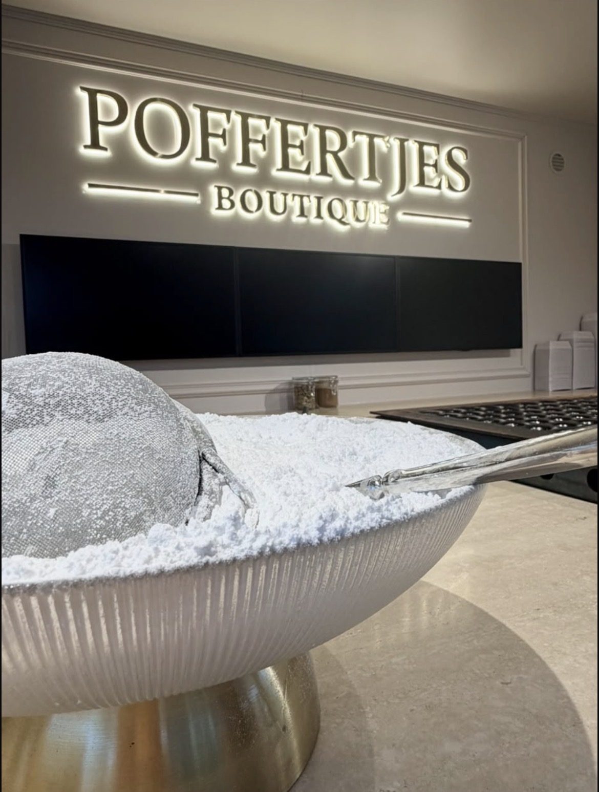 Poedersuiker over verse poffertjes bij de poffertjeskraam